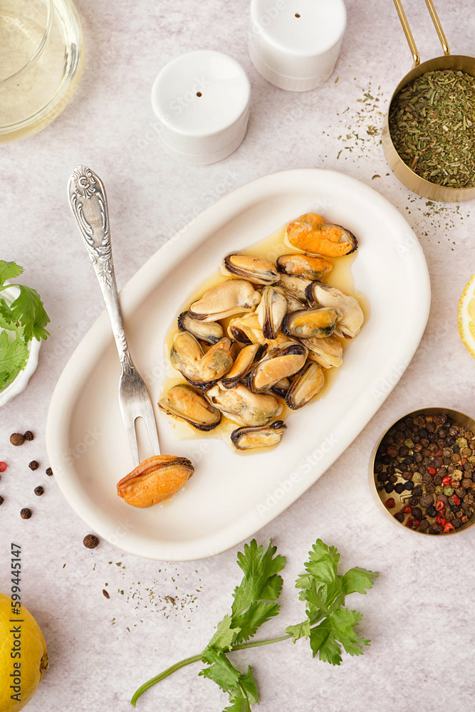 Plate with pickled mussels on white background