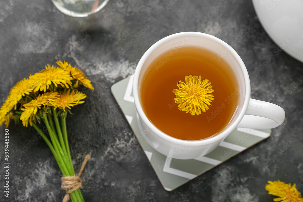 Cup of healthy dandelion tea on grey background