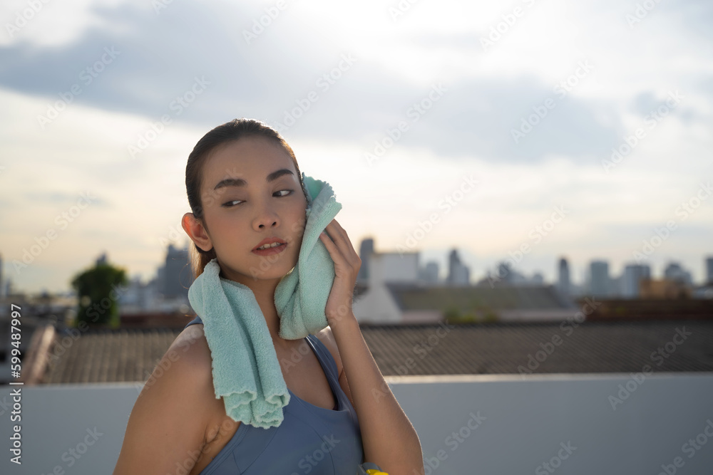 Young Asian woman resting after running exercise.outdoor exercise fitness concept