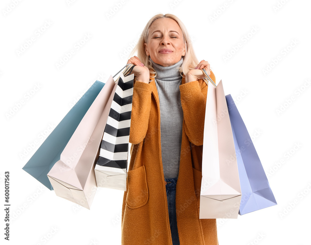 Happy mature woman with shopping bags on white background