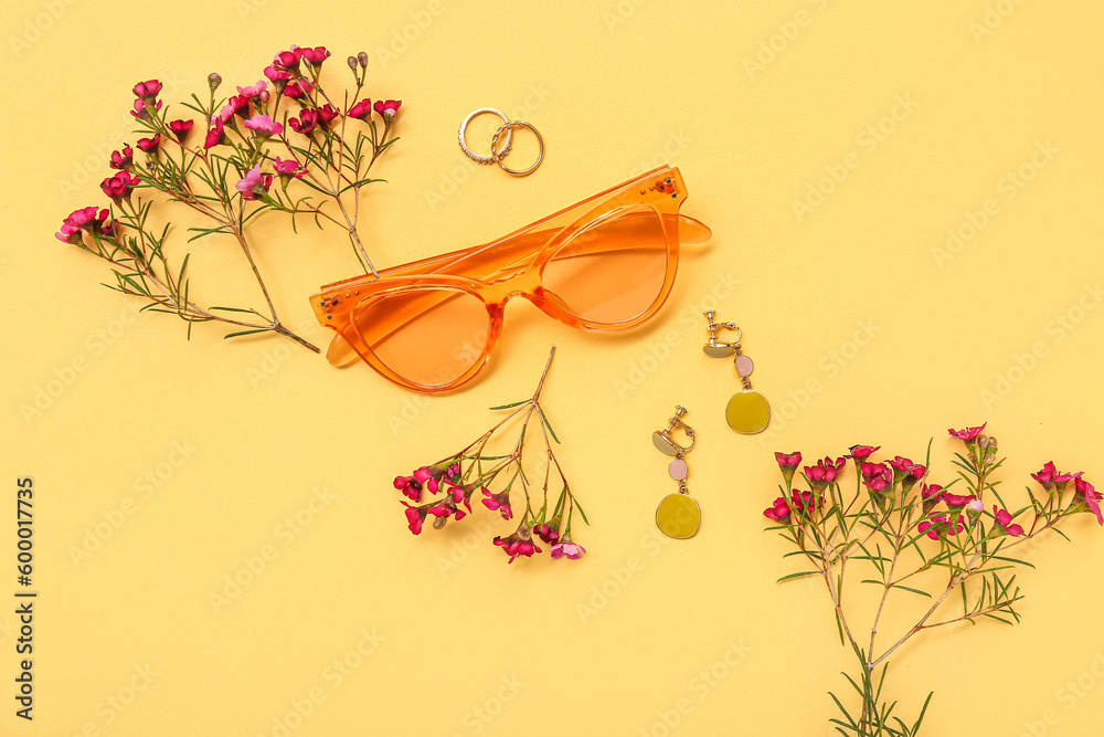 Composition with stylish female accessories and wild flowers on color background