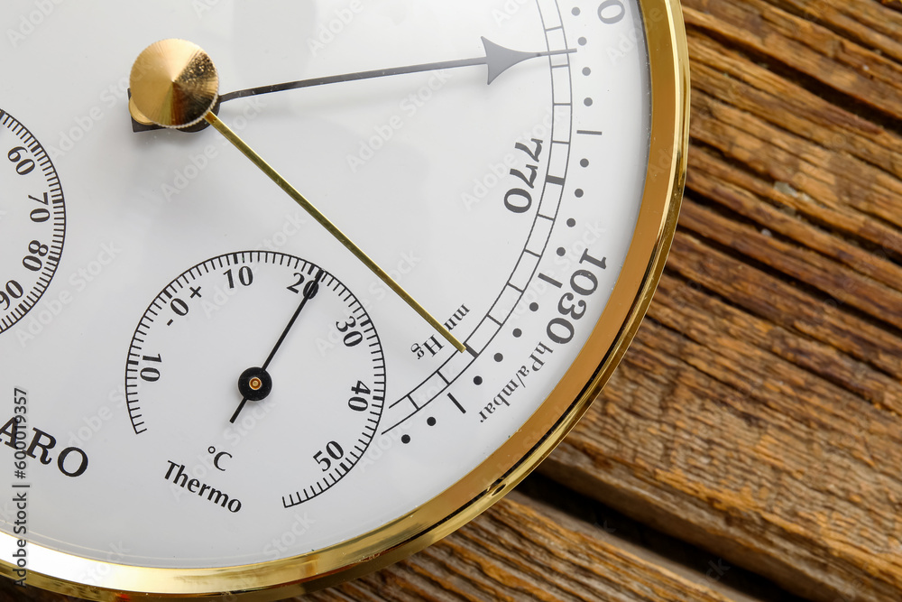 Aneroid barometer on brown wooden background