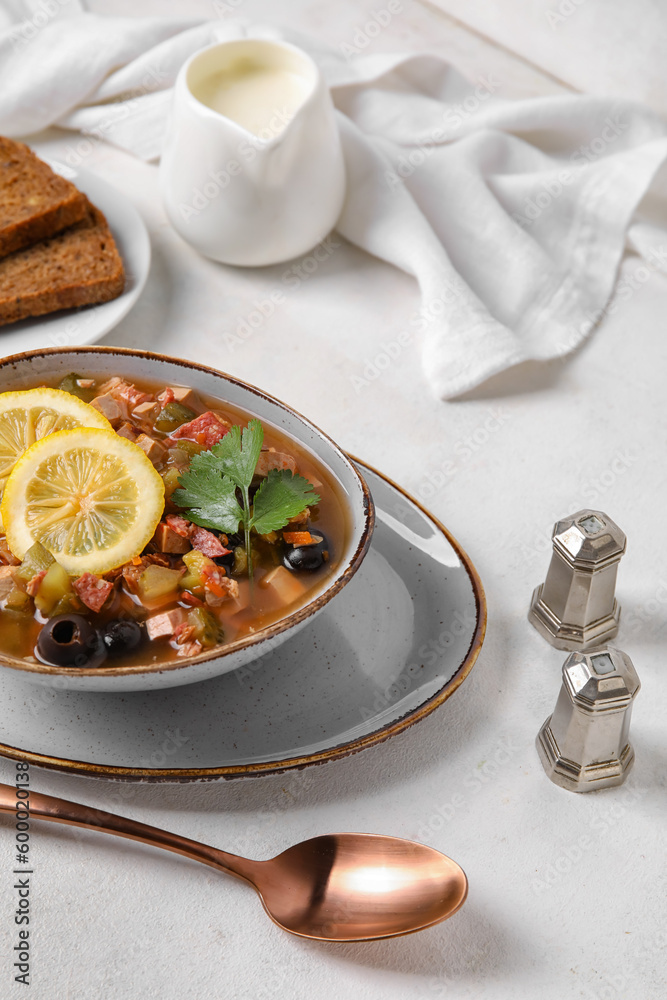 Bowl of tasty Hodgepodge soup on light background