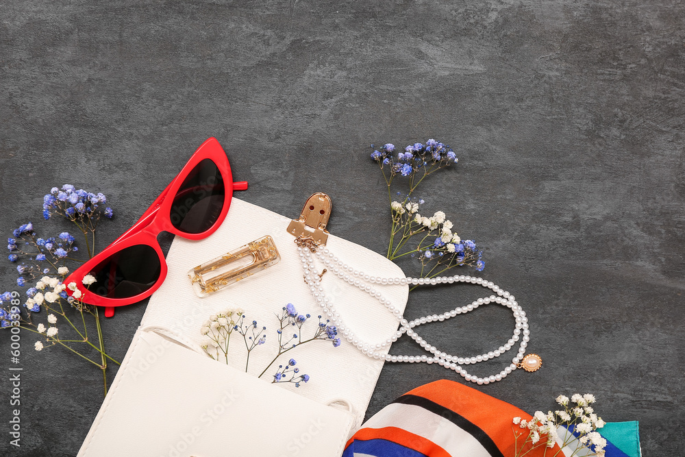 Composition with stylish female accessories and gypsophila flowers on dark background