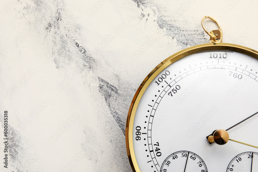 Aneroid barometer on white marble background