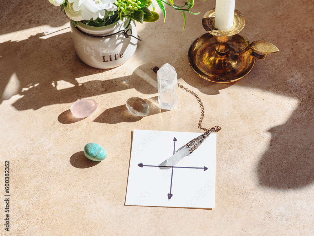 Rock crystal pendulum on the table. Stones and crystals for meditation and relaxing.