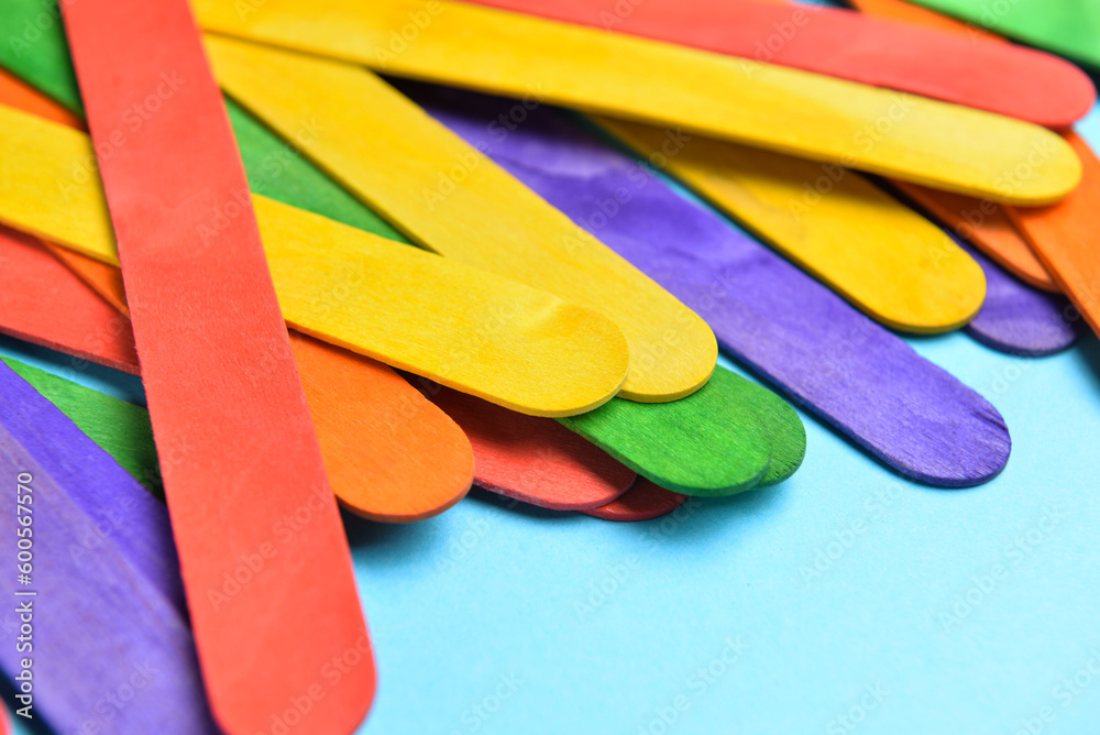 Colorful ice cream sticks on blue background, closeup