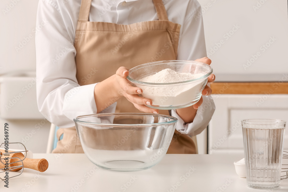 Woman making dough for Italian Grissini at white table in kitchen