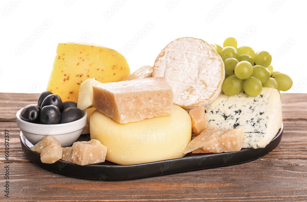 Tray with different types of tasty cheese and grapes on table against white background