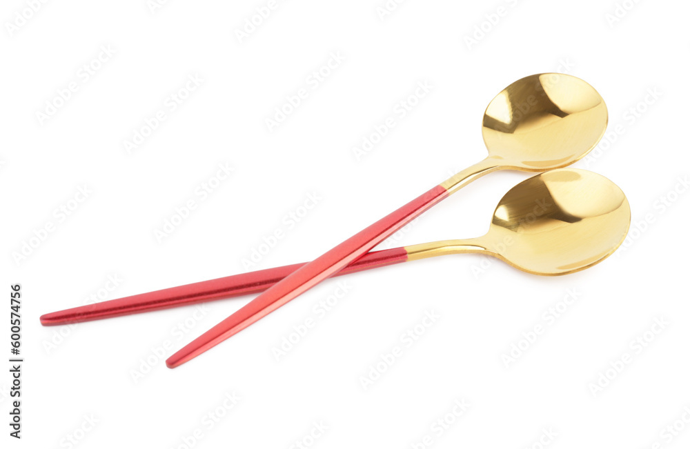 Golden spoons with red handles on white background