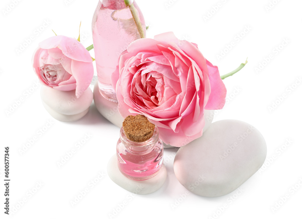 Bottles of cosmetic oil with rose extract and flowers on white background