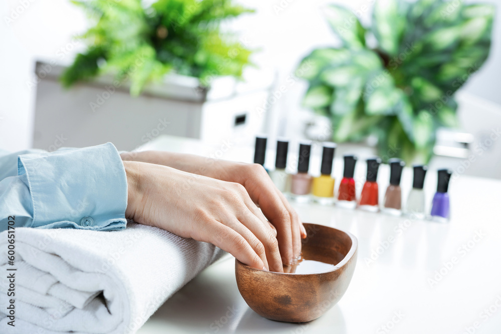 Closeup female hands in wooden bowl with water