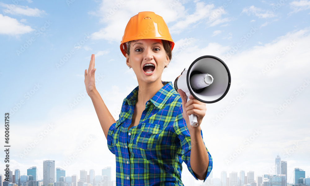 Expressive woman in helmet shouting into megaphone