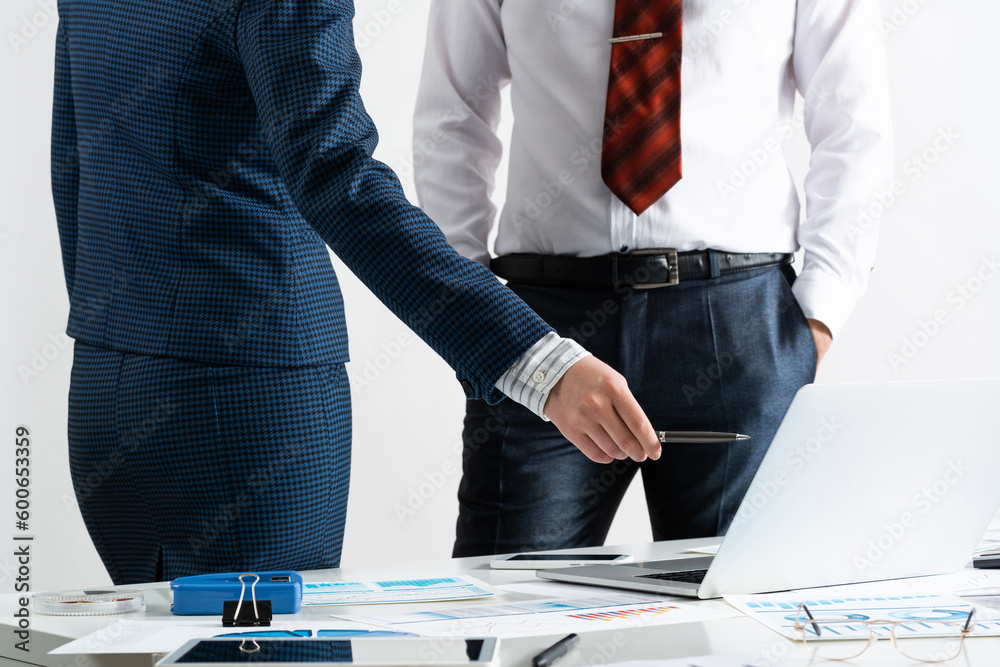 Businesspersons stand near office desk