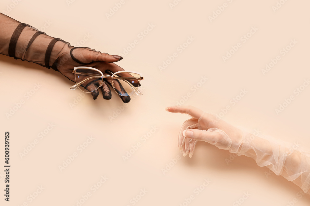 Women in laced gloves with eyeglasses on beige background