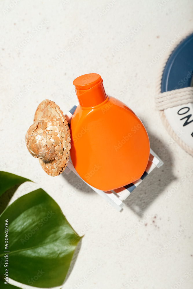 Creative composition with sunscreen cream and palm leaf on grey background