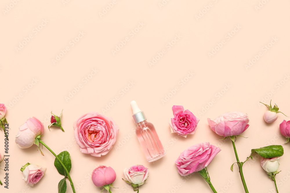 Bottle of cosmetic oil with rose extract and flowers on beige background