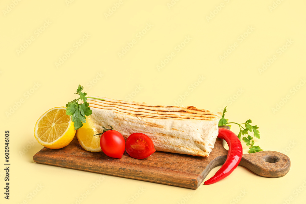 Board with tasty shawarma and ingredients on beige background