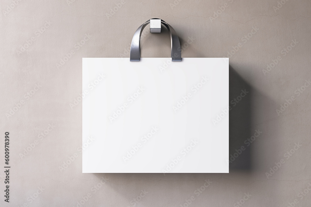 Shopping or present concept with front view on blank white paper bag with silver handles and place f