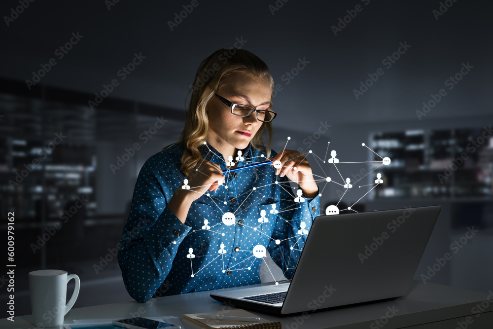 Attractive blonde wearing glasses in dark office using laptop. Mixed media