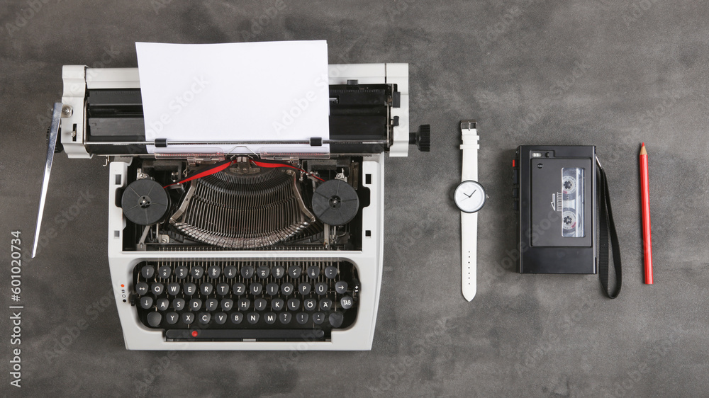 vintage typewriter and tape recorder on the table with blank paper on the desk - concept for writing