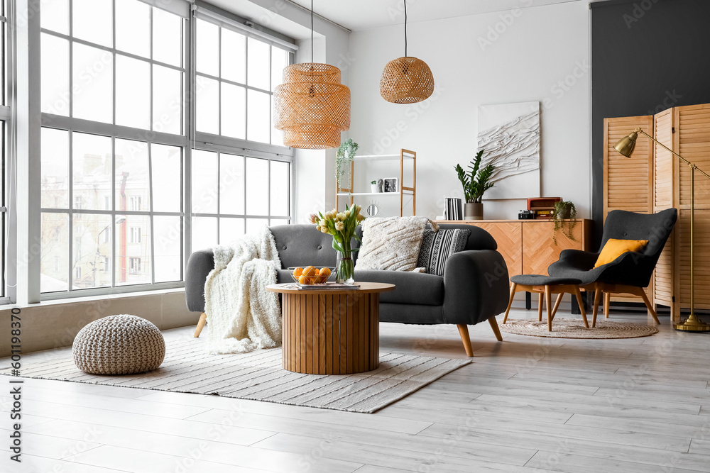 Interior of stylish living room with cozy sofa and coffee table near big window