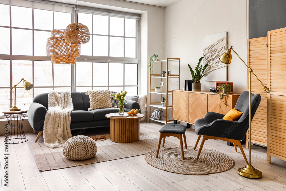 Interior of stylish living room with cozy sofa and coffee table near big window