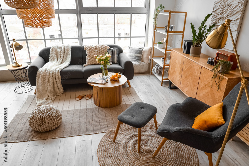 Interior of stylish living room with cozy sofa and coffee table near big window