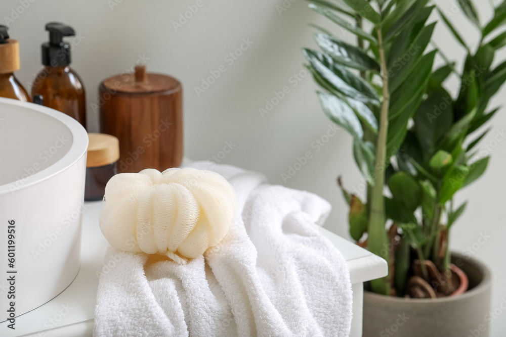 Different cosmetic products, towel and sponge in bathroom