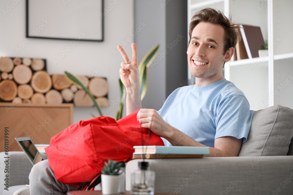 Male student with backpack at home