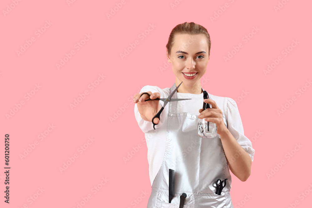 Female hairdresser with scissors and spray on pink background