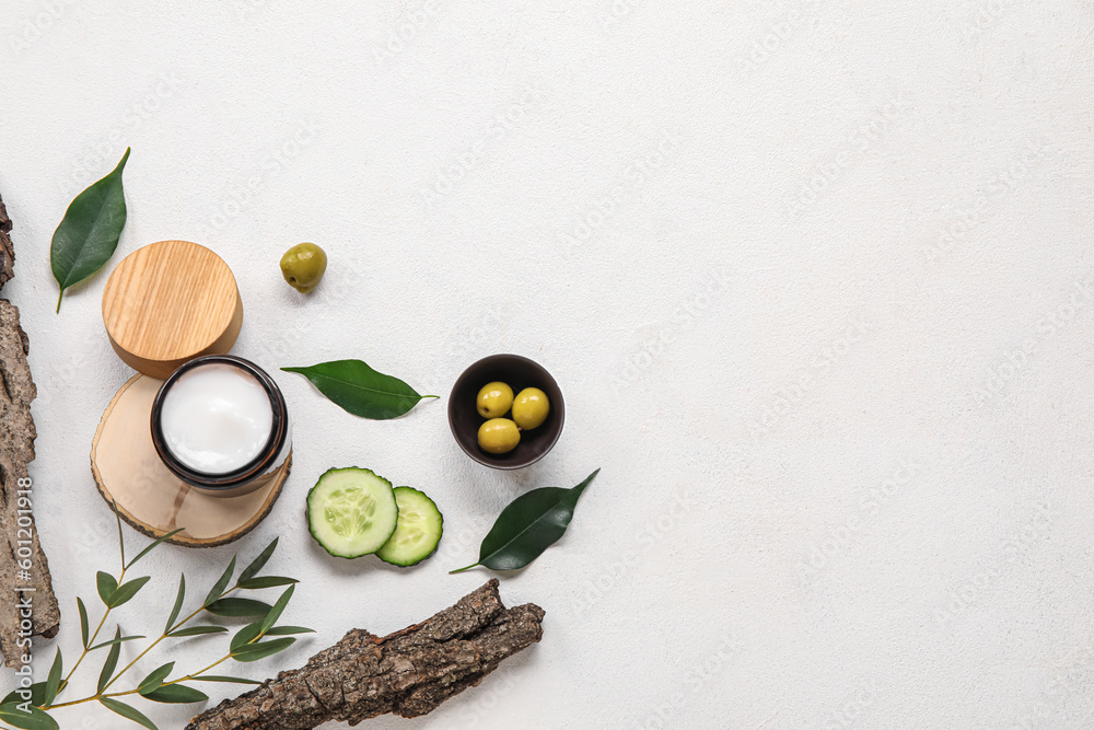 Composition with jar of cream and natural ingredients on light background