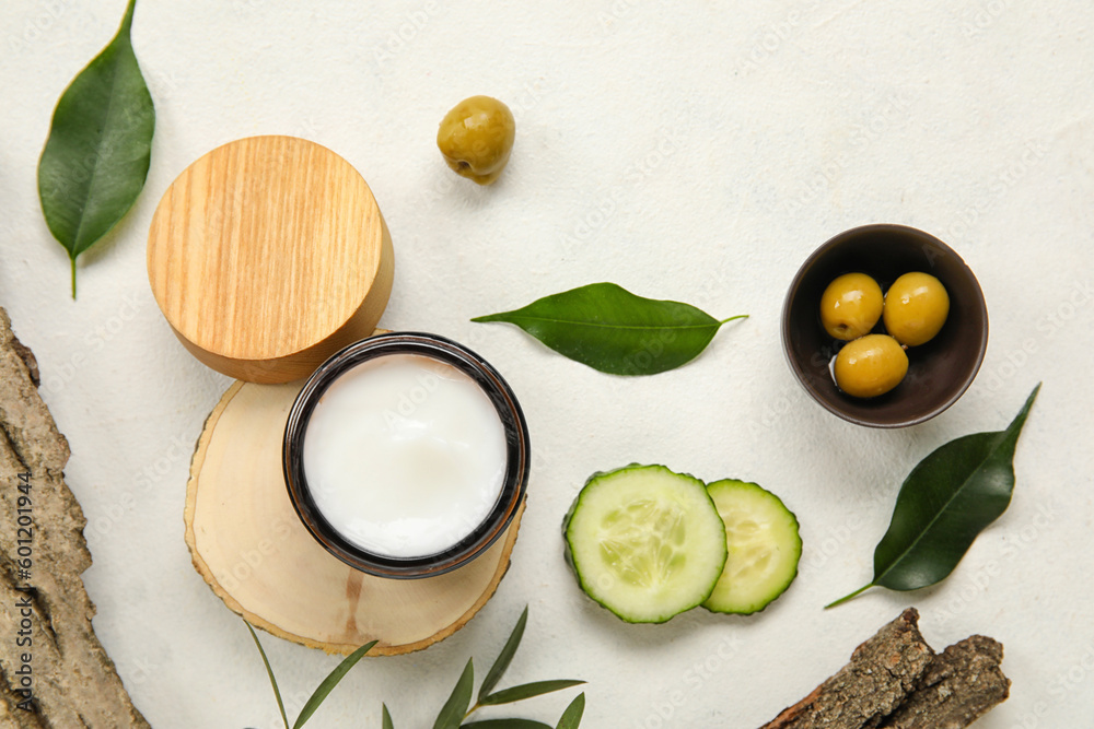 Composition with jar of cream and natural ingredients on light background