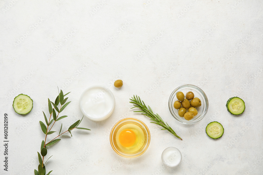 Composition with jars of cream and natural ingredients on light background