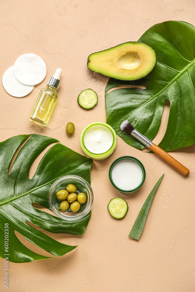 Composition with natural cosmetics, ingredients and palm leaves on color background