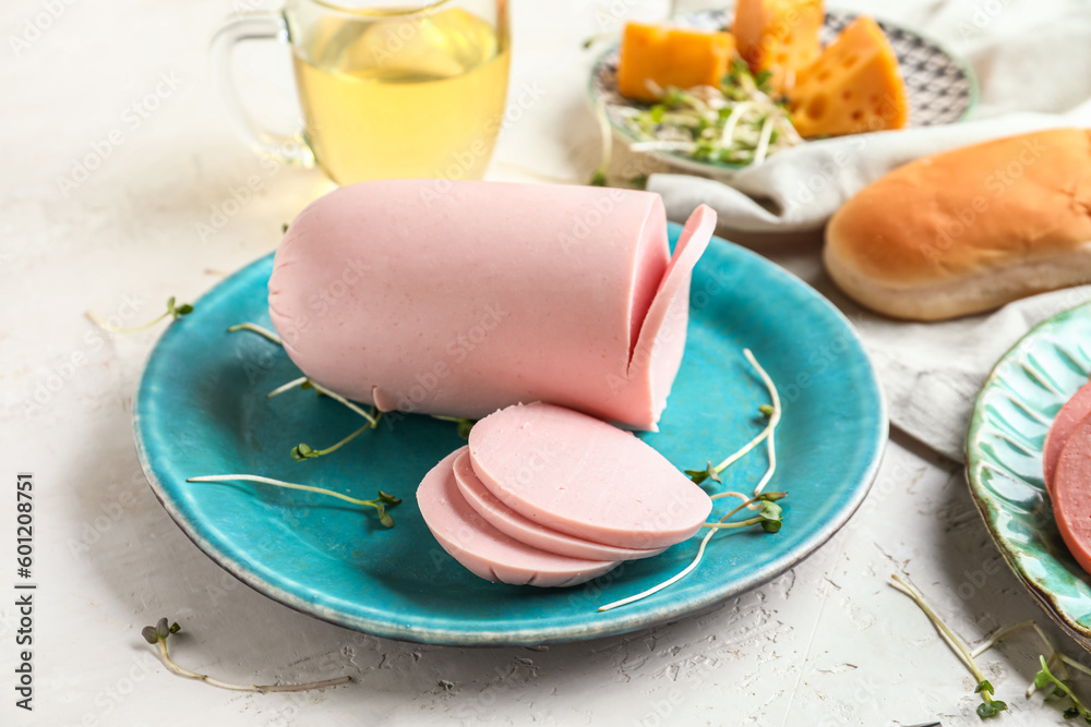 Plate with tasty boiled sausage on light background