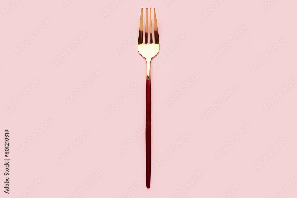 Stainless steel fork on pink background