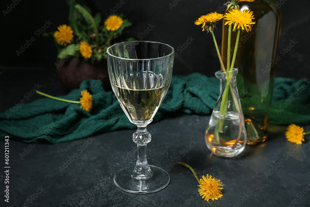 Glass of dandelion wine on dark table