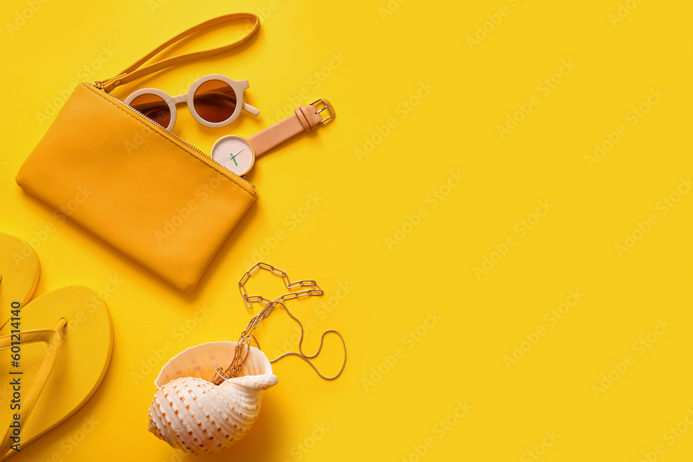 Stylish bag with watch and different accessories on yellow background