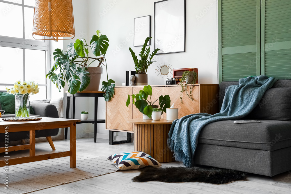 Interior of stylish living room with cozy sofa, table and wooden cabinet