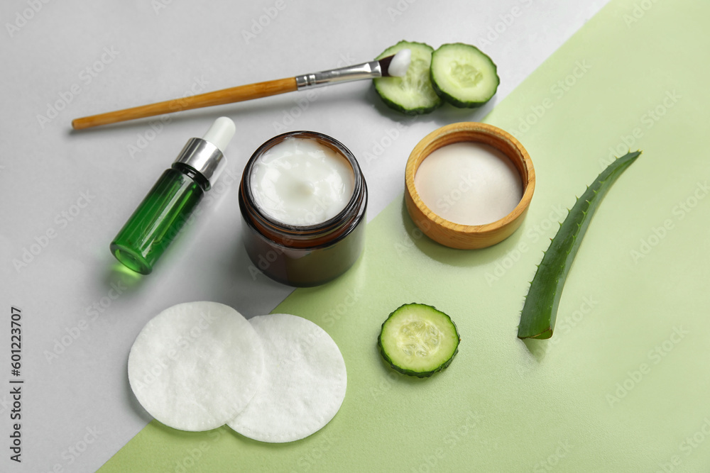 Composition with natural cosmetics, ingredients and cotton pads on color background