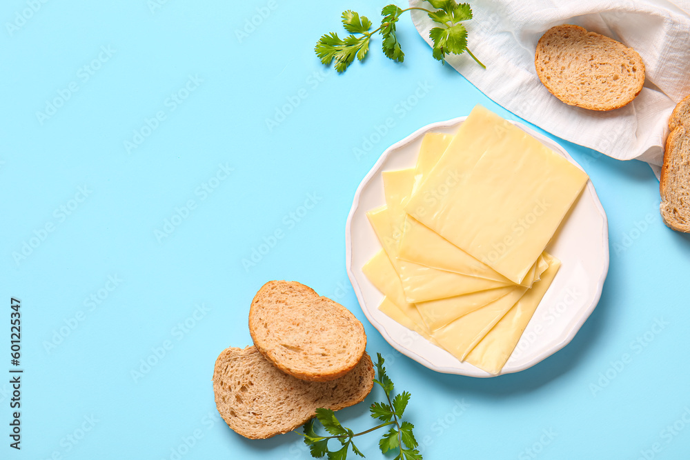 Plate of tasty processed cheese with bread on blue background