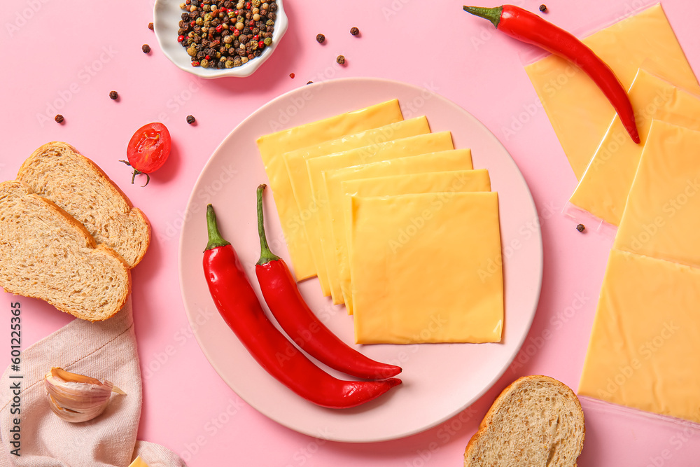 Plate of tasty processed cheese with bread and chilli on pink background