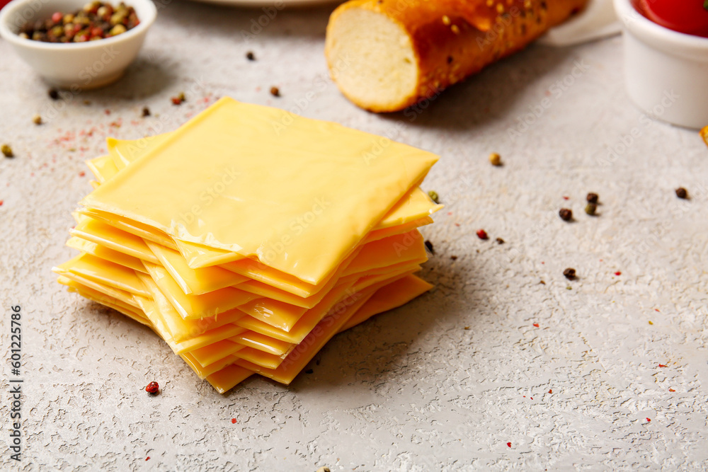 Slices of tasty processed cheese on light background