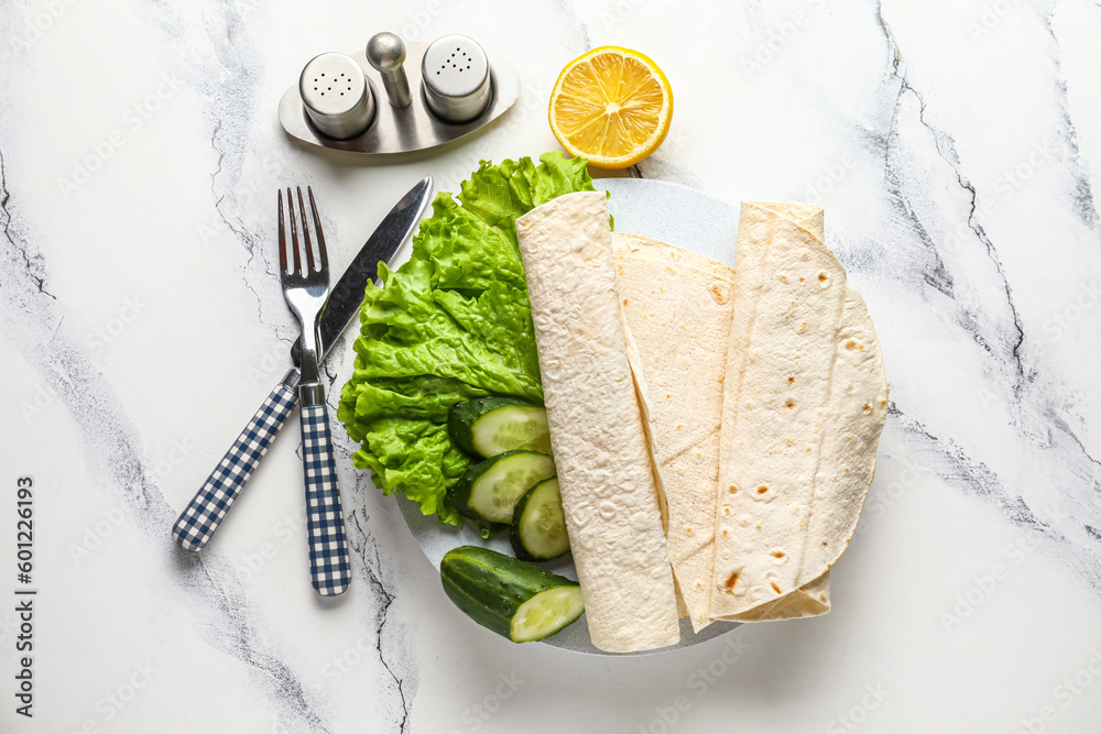 Plate with fresh lavash and vegetables on white marble background