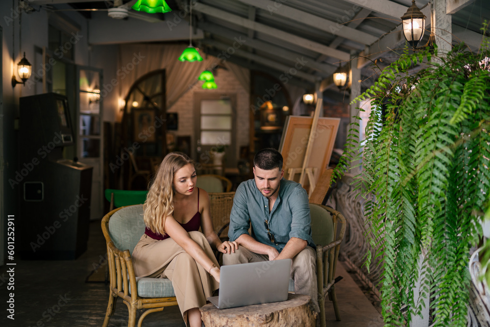 Loving young couple looking at laptop together at cozy home office. The concept of couples sharing o