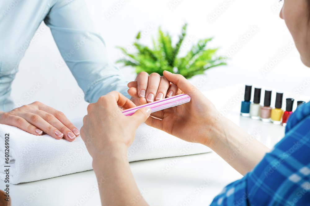 Manicurist using nail file and create nails shape