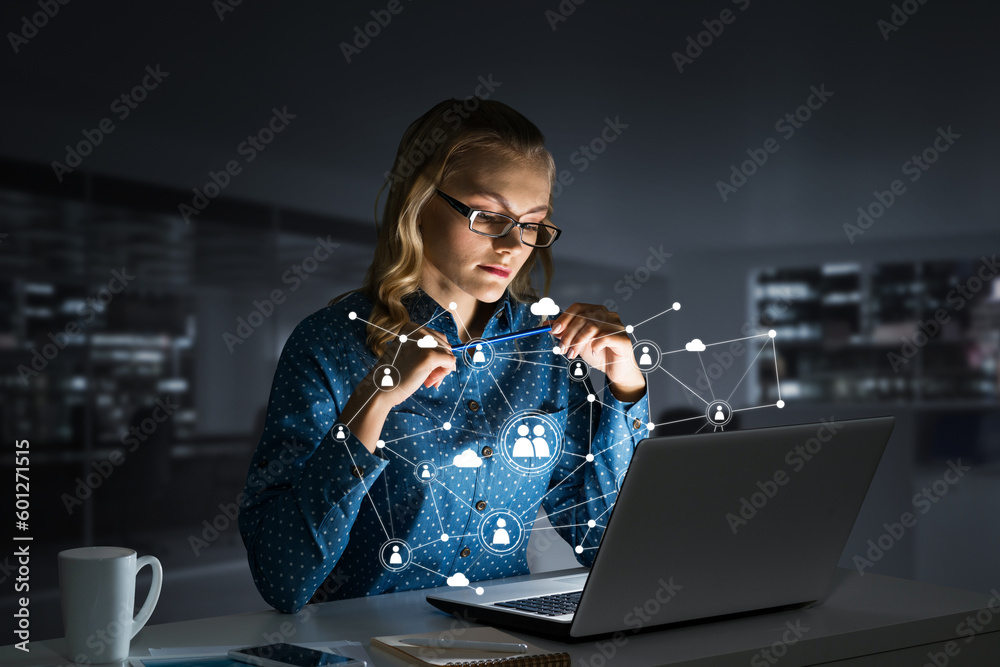 Attractive blonde wearing glasses in dark office using laptop. Mixed media