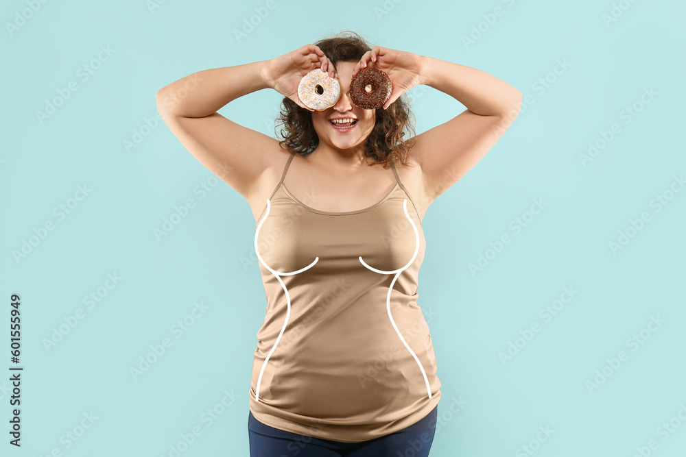 Overweight woman with donuts on light blue background. Diet concept