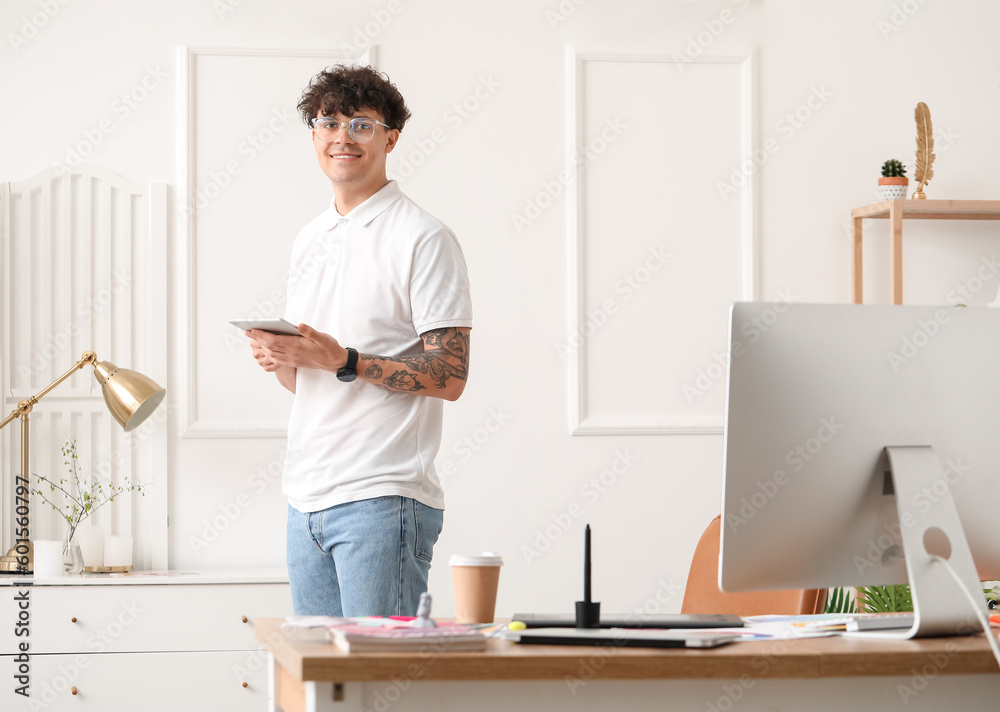 Male graphic designer with tablet computer working in office